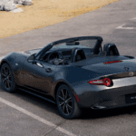 Mazda MX-5 Miata convertible parked near coastal walkway