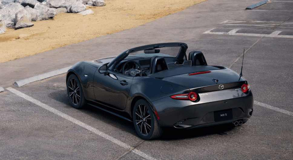 Mazda MX-5 Miata convertible parked near coastal walkway