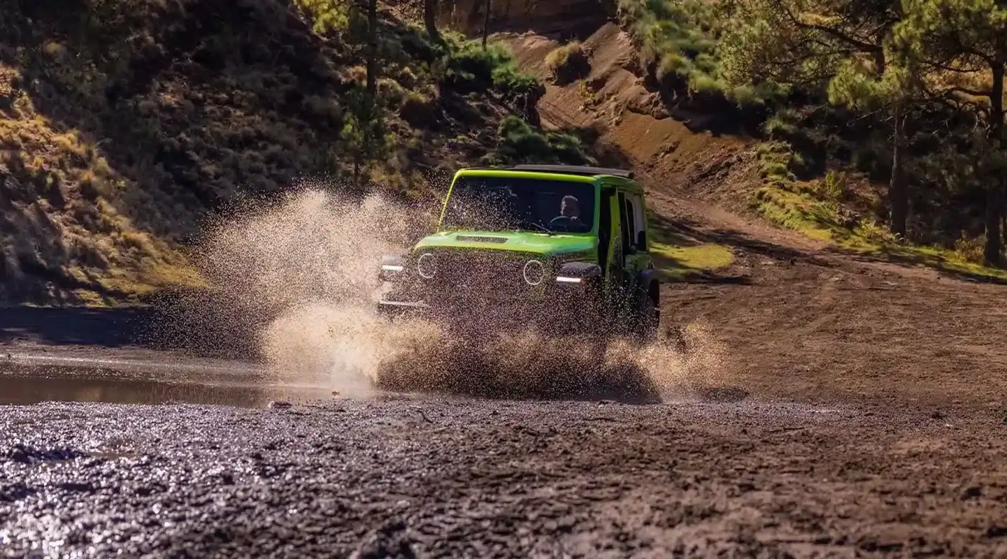 Jeep Wrangler parked in front of lake