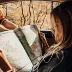 girl with road trip map in car.