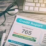 credit score paper laying next to glasses and keyboard