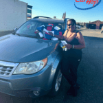 carhop customers smiling with their new suv with a bow