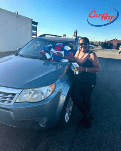 carhop customers smiling with their new suv with a bow