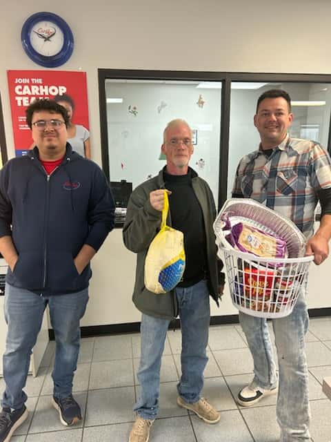 Customers of CarHop of Springfield proudly holding their Thanksgiving baskets, complete with a turkey and holiday meal essentials.