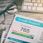credit score paper laying next to glasses and keyboard