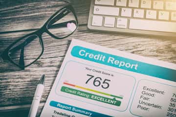 credit score paper laying next to glasses and keyboard
