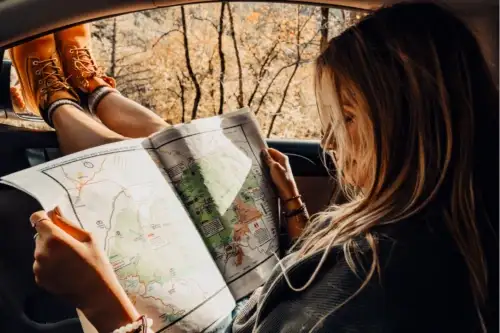 girl with map open in car