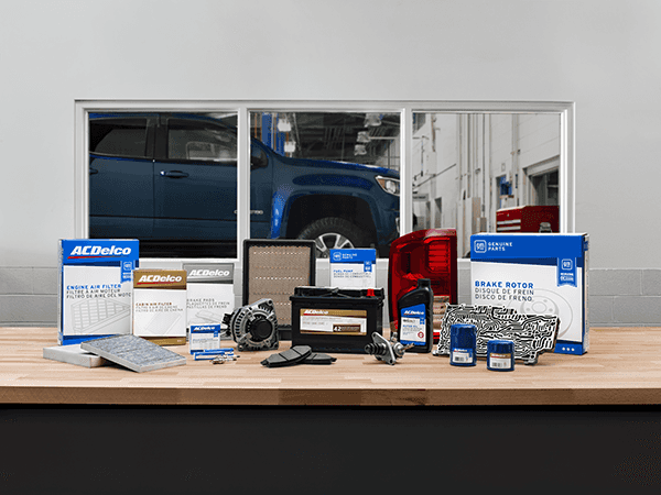 Cadillac OEM AC Delco and GM Genuine Parts sitting upright on a workbench inside an automotive workshop