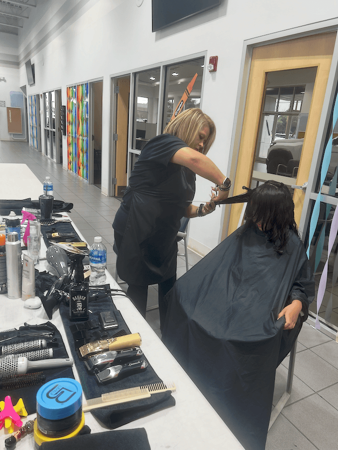 Child receiving a haircut during the Cuts for Kids event