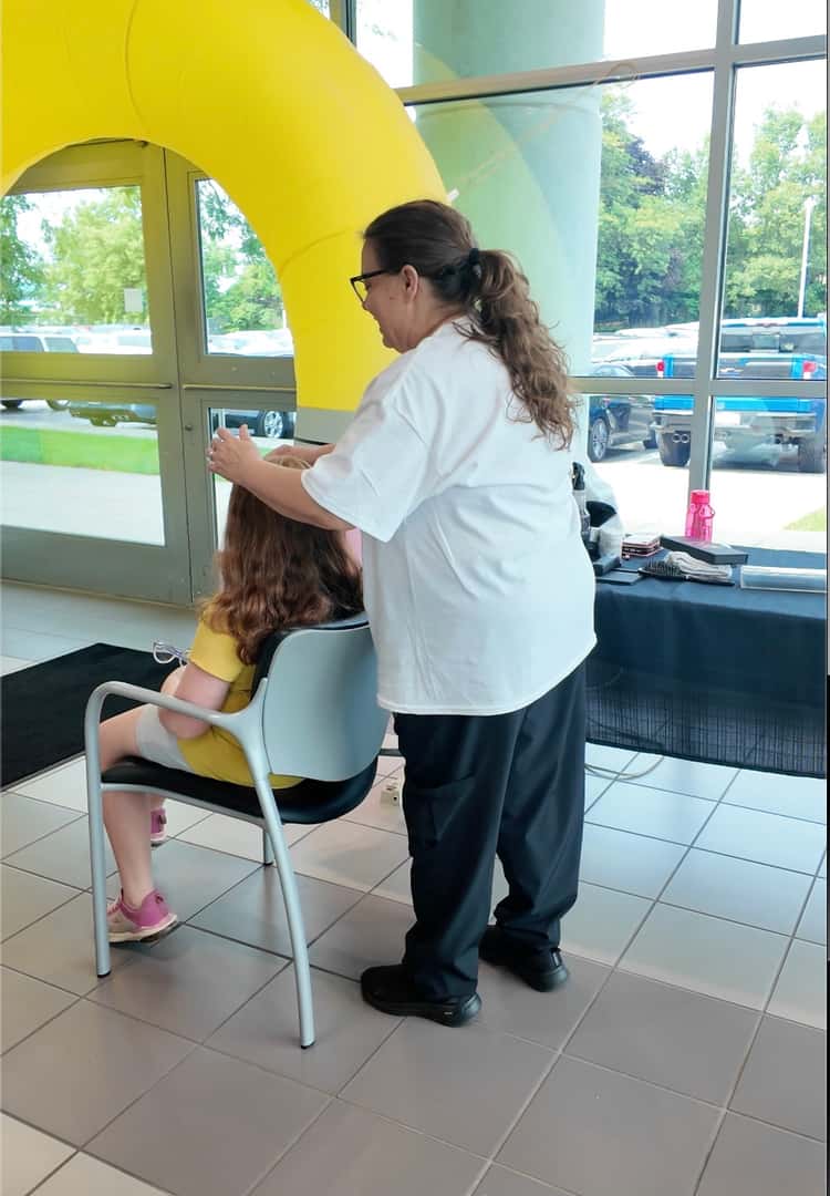 Local student receiving a free haircut during the Cars and Cuts back-to-school event