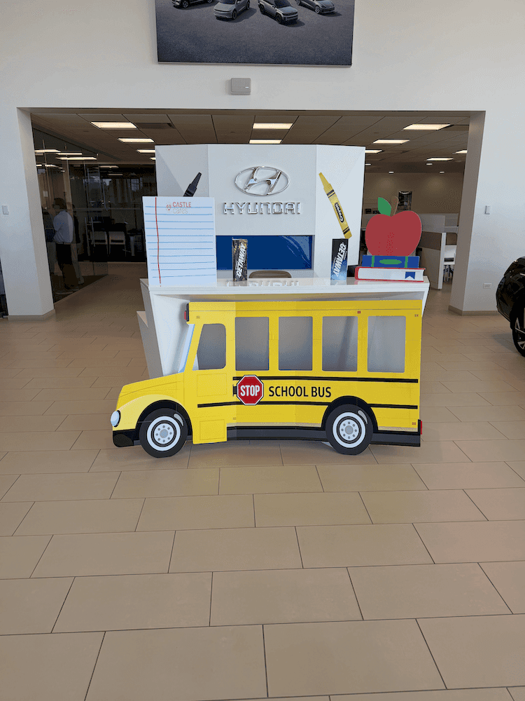 Back to School Pit Stop display at Castle Hyundai Downers Grove featuring school bus decorations