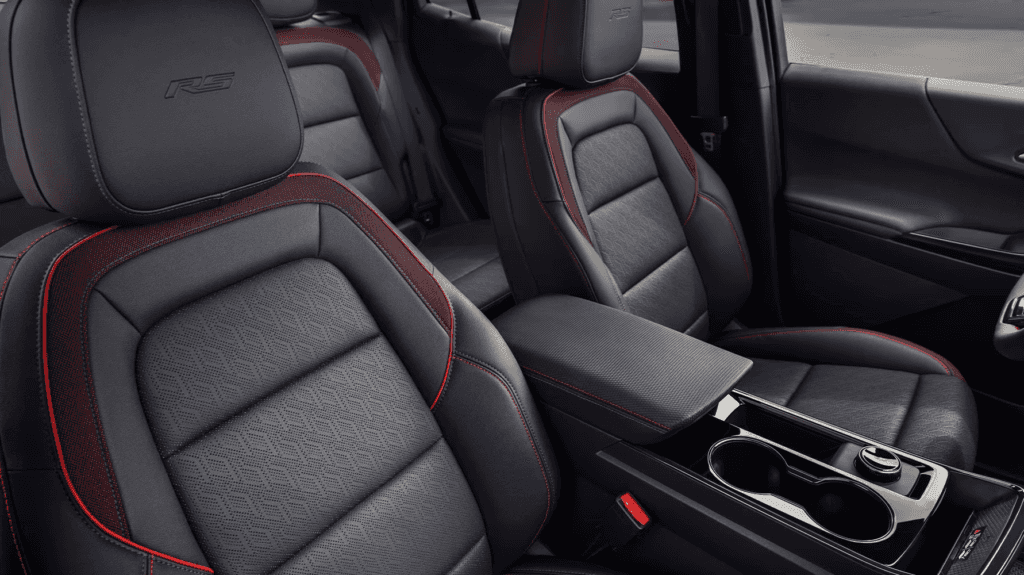 Front seats of the 2026 Chevrolet Equinox with black leather upholstery, red stitching, and RS logo embossed on the headrests.