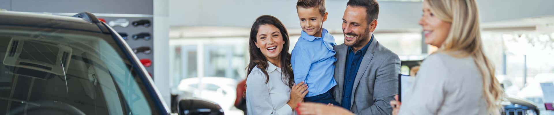 Couple with child looking a vehicle