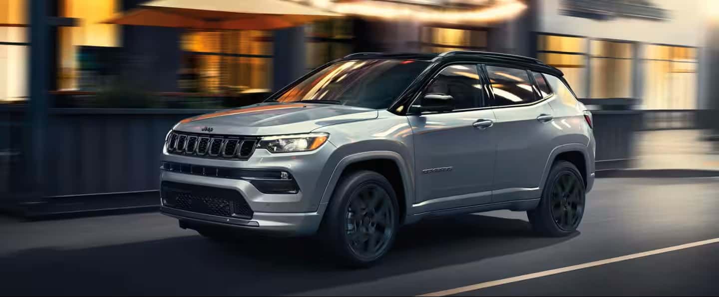 silver 2025 jeep compass driving in the city