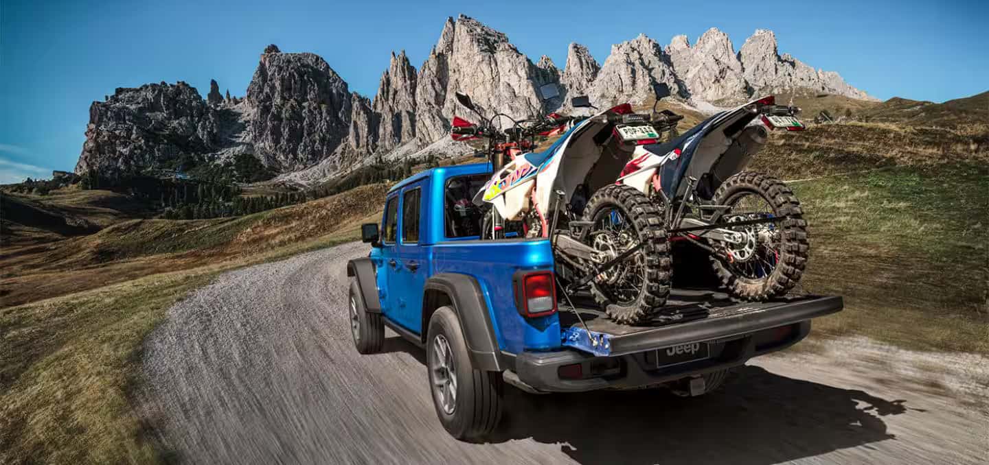 2026 Jeep Gladiator with dirt bikes in the bed of truck