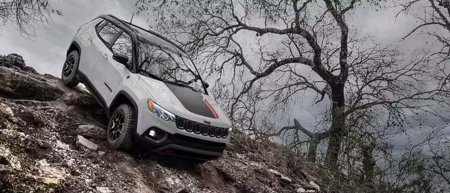 2026 jeep compass driving down the side of a rocky mountain