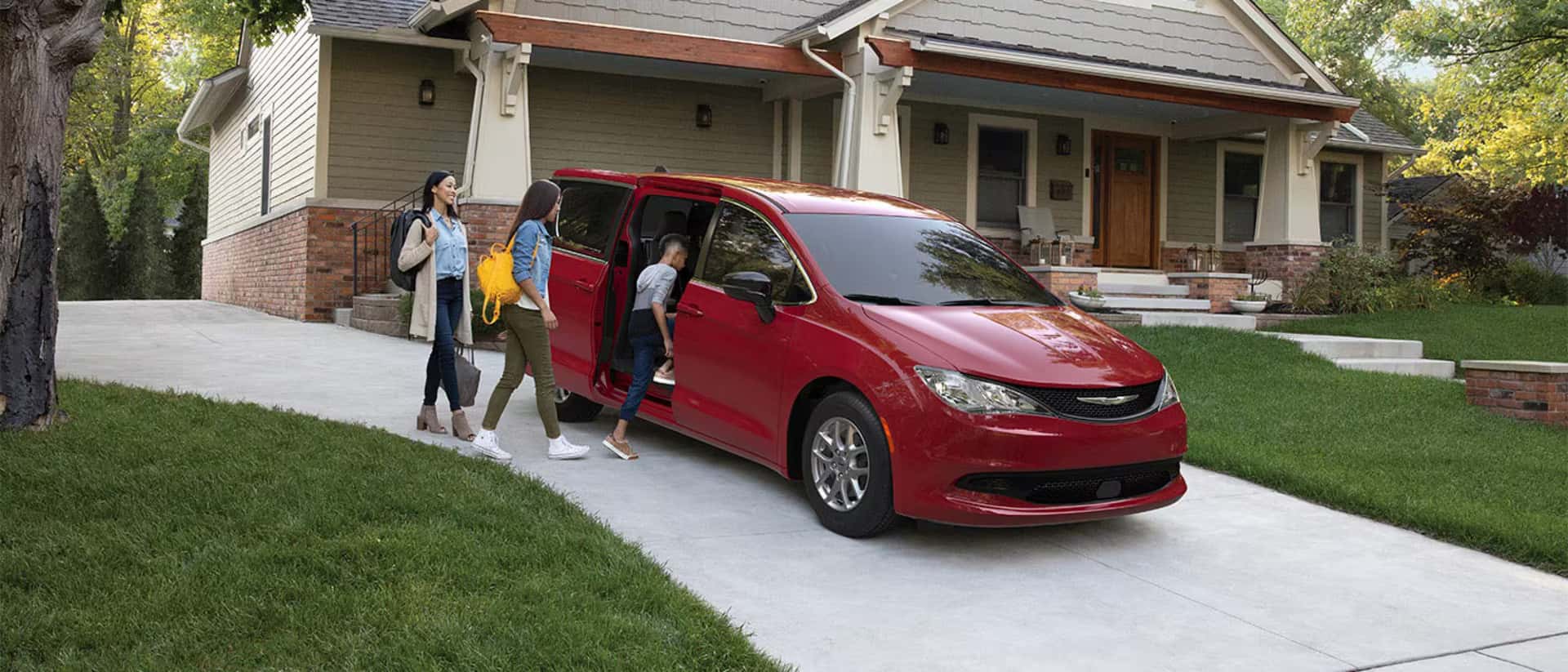 A view of the New 2026 Chrysler Voyager parked in the driveway of a home