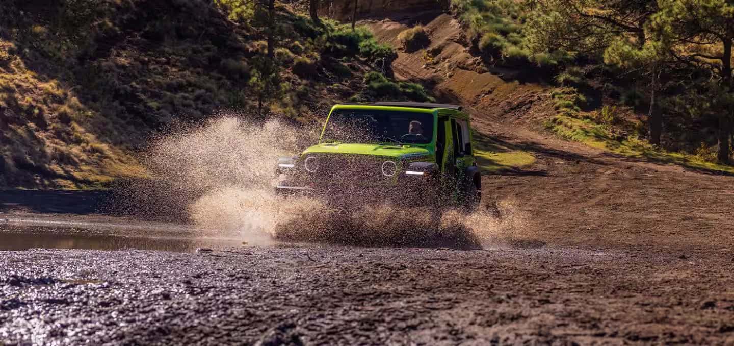 a 2026 Jeep Wrangler driving through a creek
