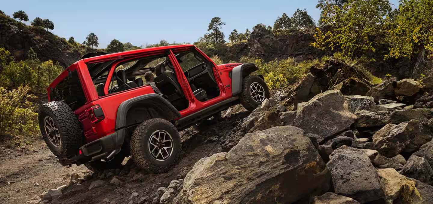 a 2026 Jeep Wrangler driving up some rocks