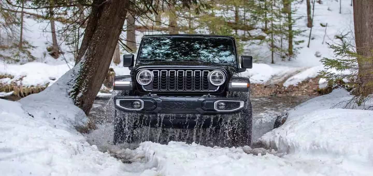 a 2026 Jeep Wrangler driving on a snowy road