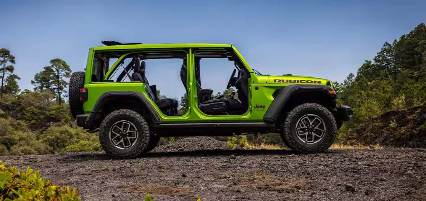 a green 2026 Jeep Wrangler parked on a gravel road