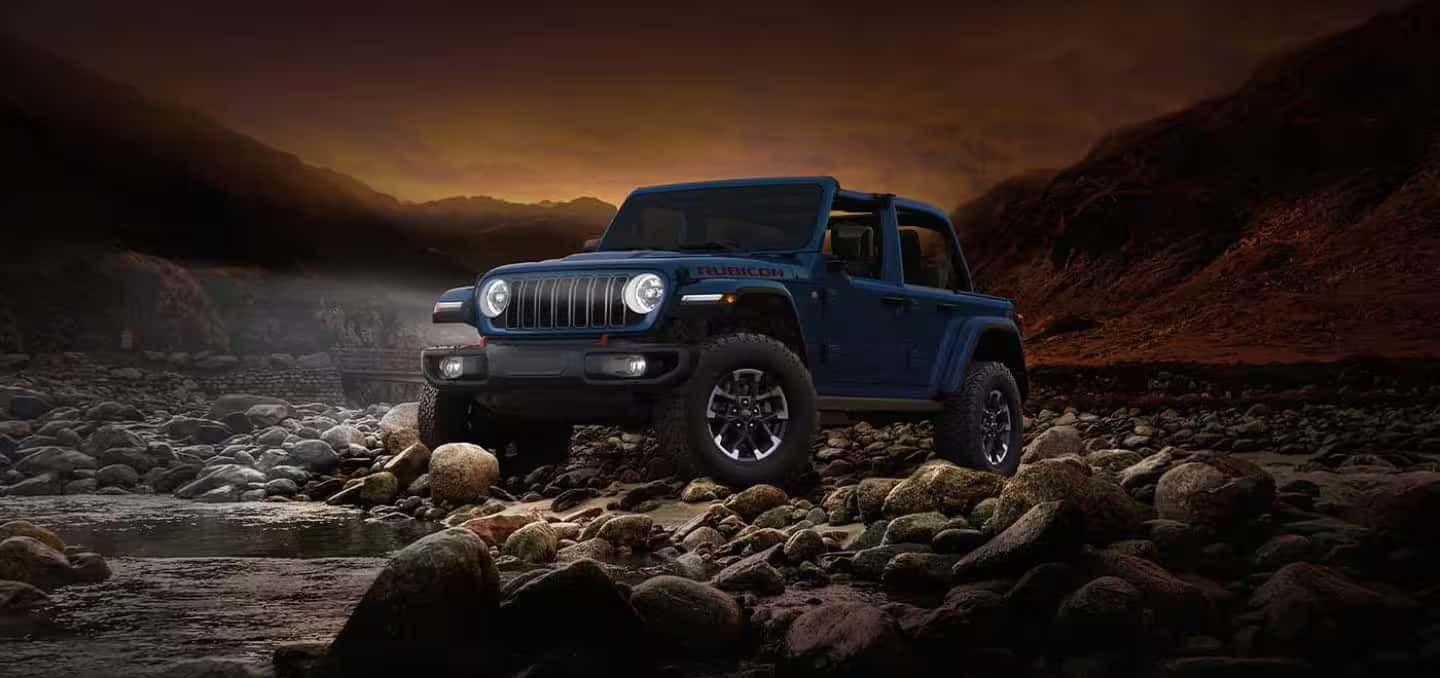 2026 Jeep Wrangler parked on rocks next to a creek