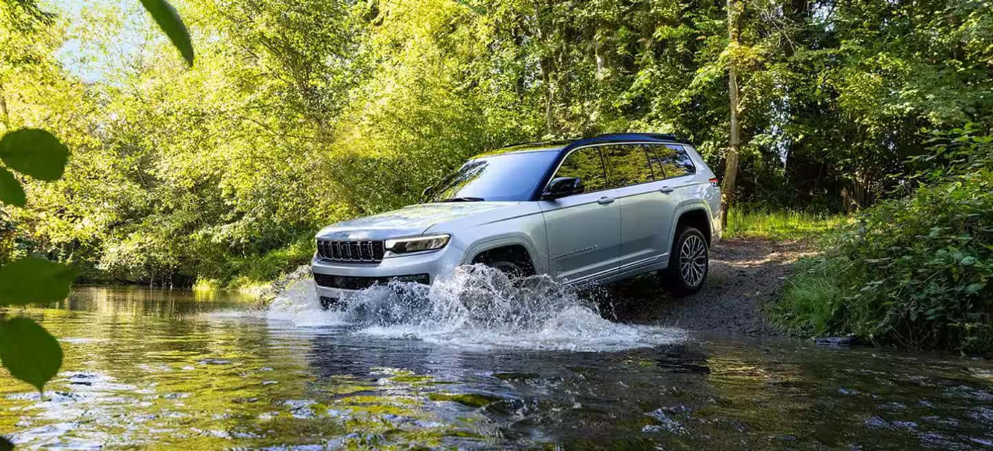 2026 Jeep Grand Cherokee driving through a creek