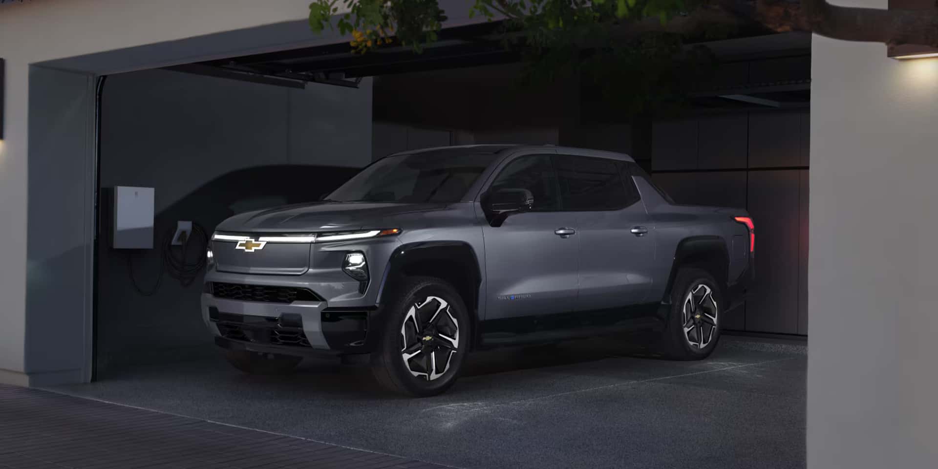 2026 Chevy Silverado EV parked next to an at home charging station