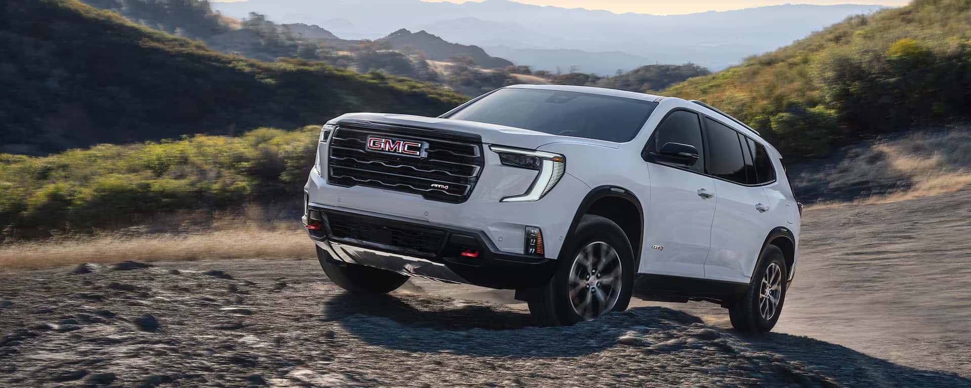 2026 GMC Acadia driving up a hill