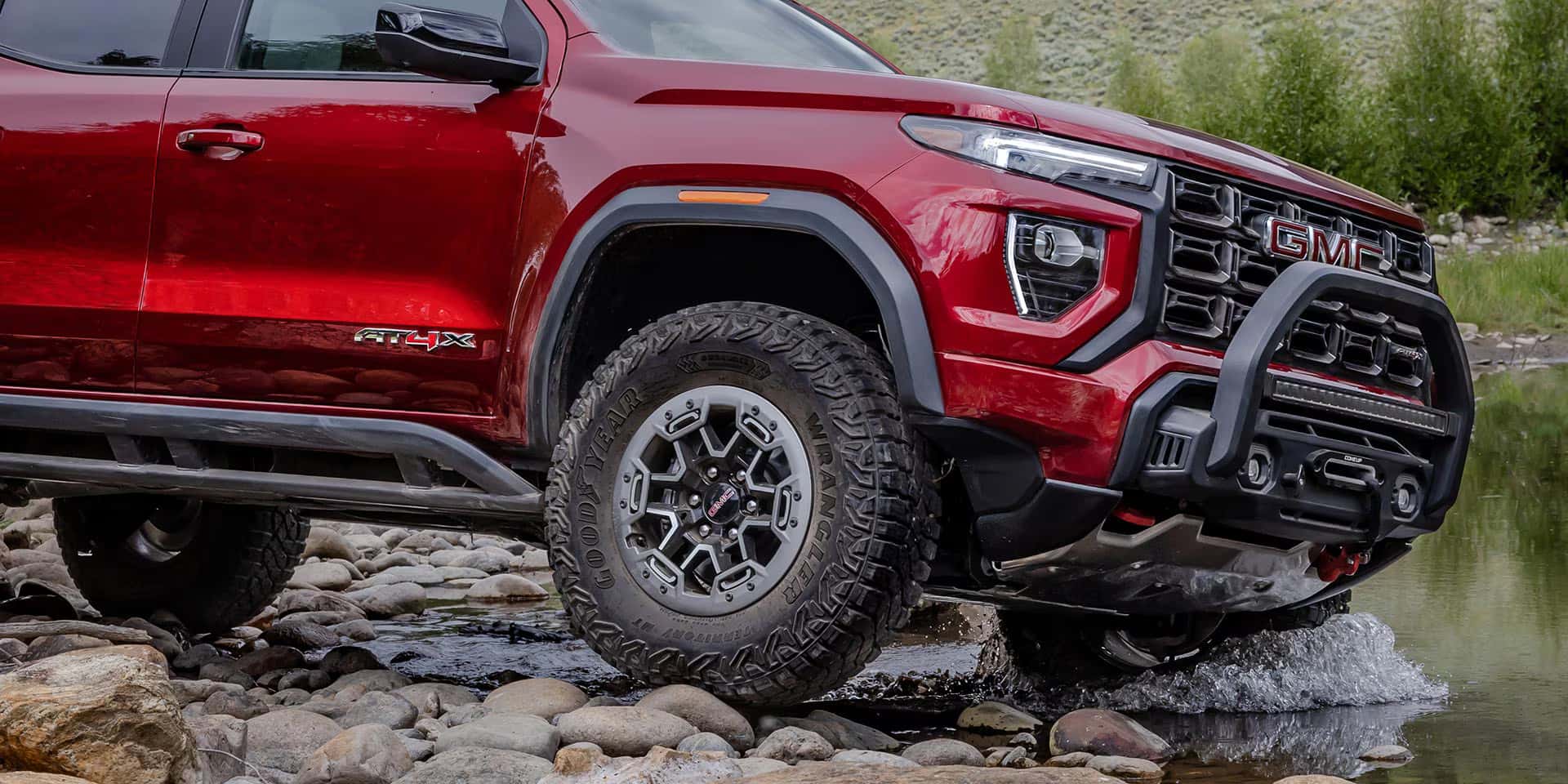 2026 GMC Canyon driving by a creek