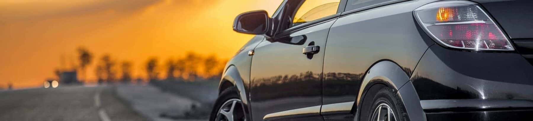 Black sedan with a sunset in the background