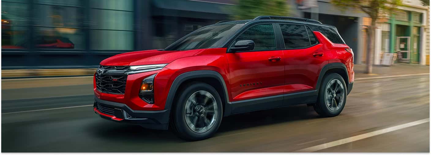 Front three-quarter view of a red 2026 Chevrolet Equinox driving on a city street.