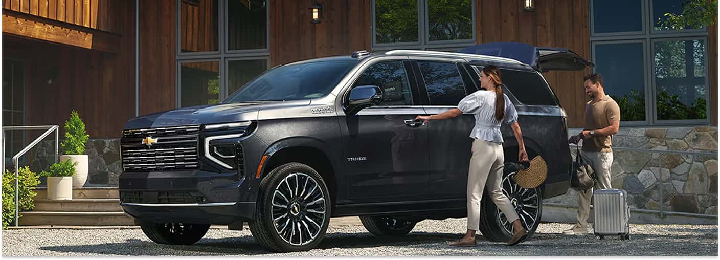 Front three-quarter view of a dark gray 2026 Chevrolet Tahoe parked while loading cargo.