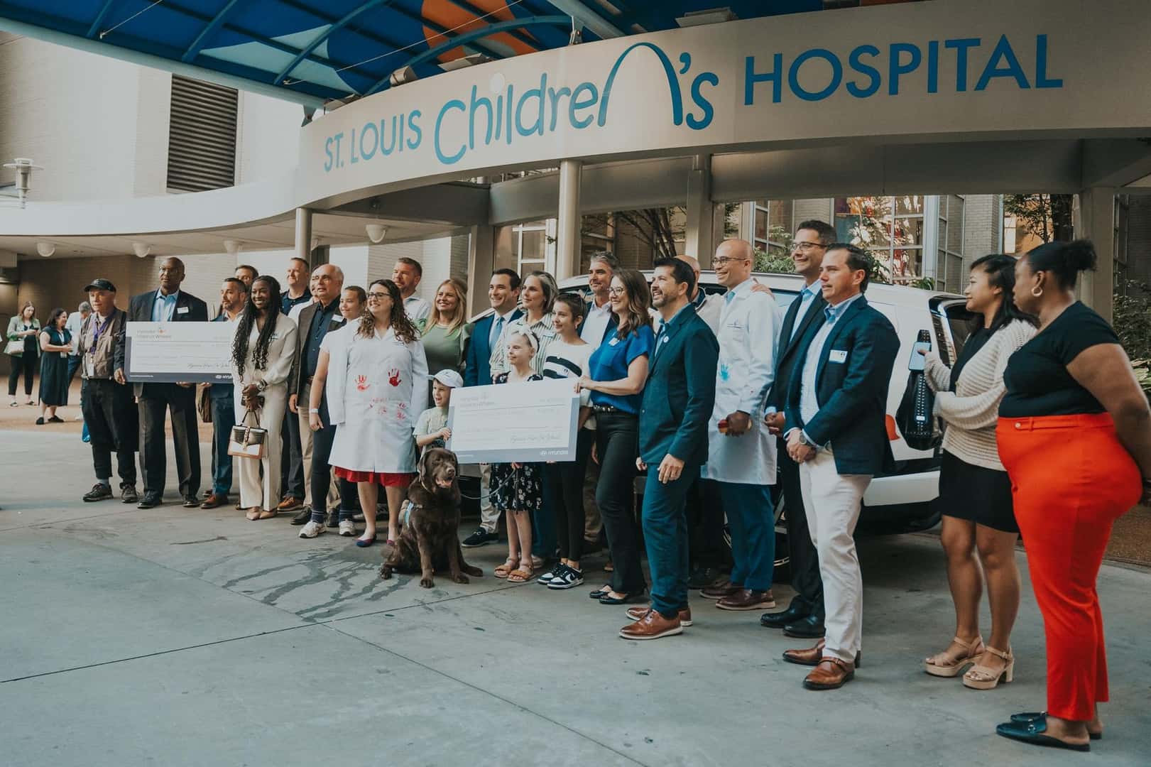 Children placing handprints on Hyundai vehicle as part of Hope On Wheels