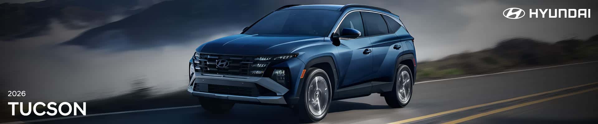 Blue Hyundai Tucson driving on a winding road, shown from the front three-quarter view.