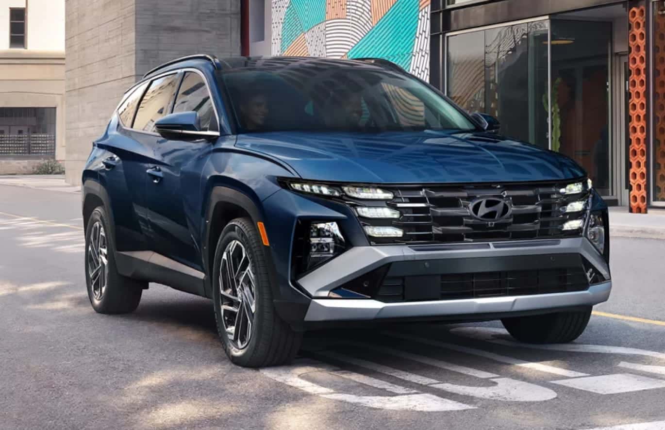 Blue Hyundai Tucson shown from the front three-quarter view on a city street.