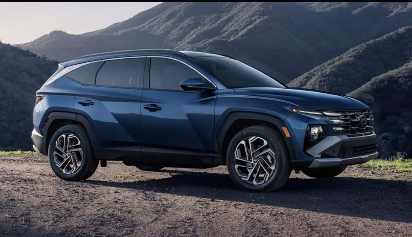 Blue Hyundai Tucson shown from the front three-quarter view in a mountainous outdoor setting.