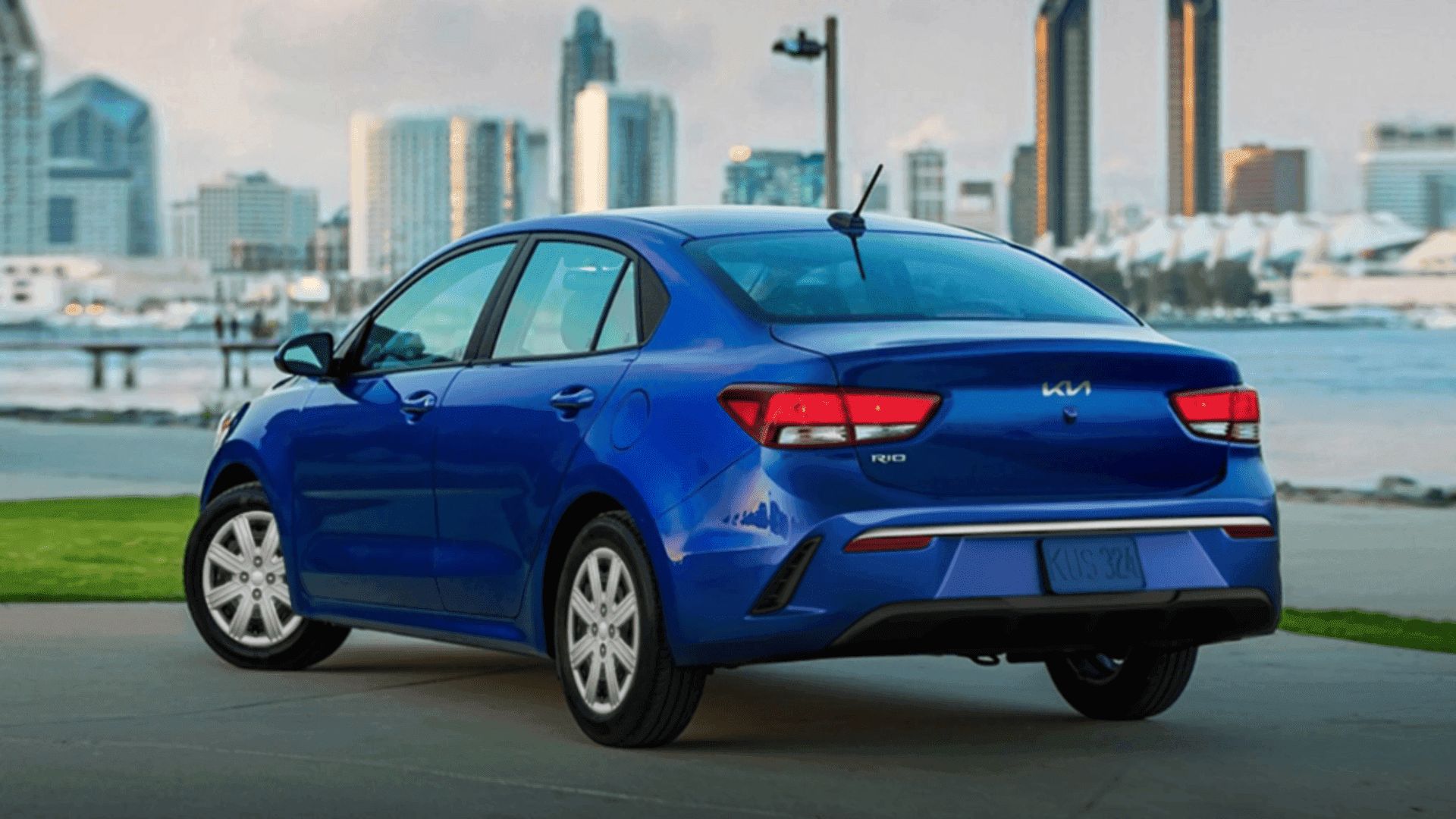 8. Rear view of 2023 Kia Rio with city skyline in the background
