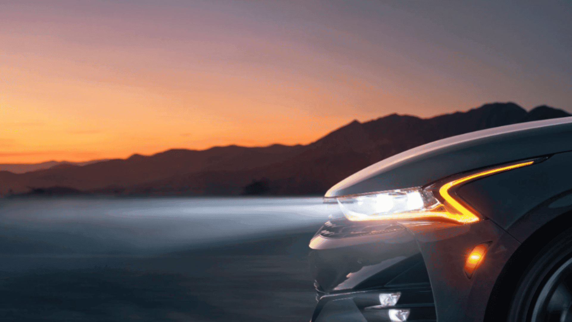 K5 LED headlights shining at sunset with mountain backdrop