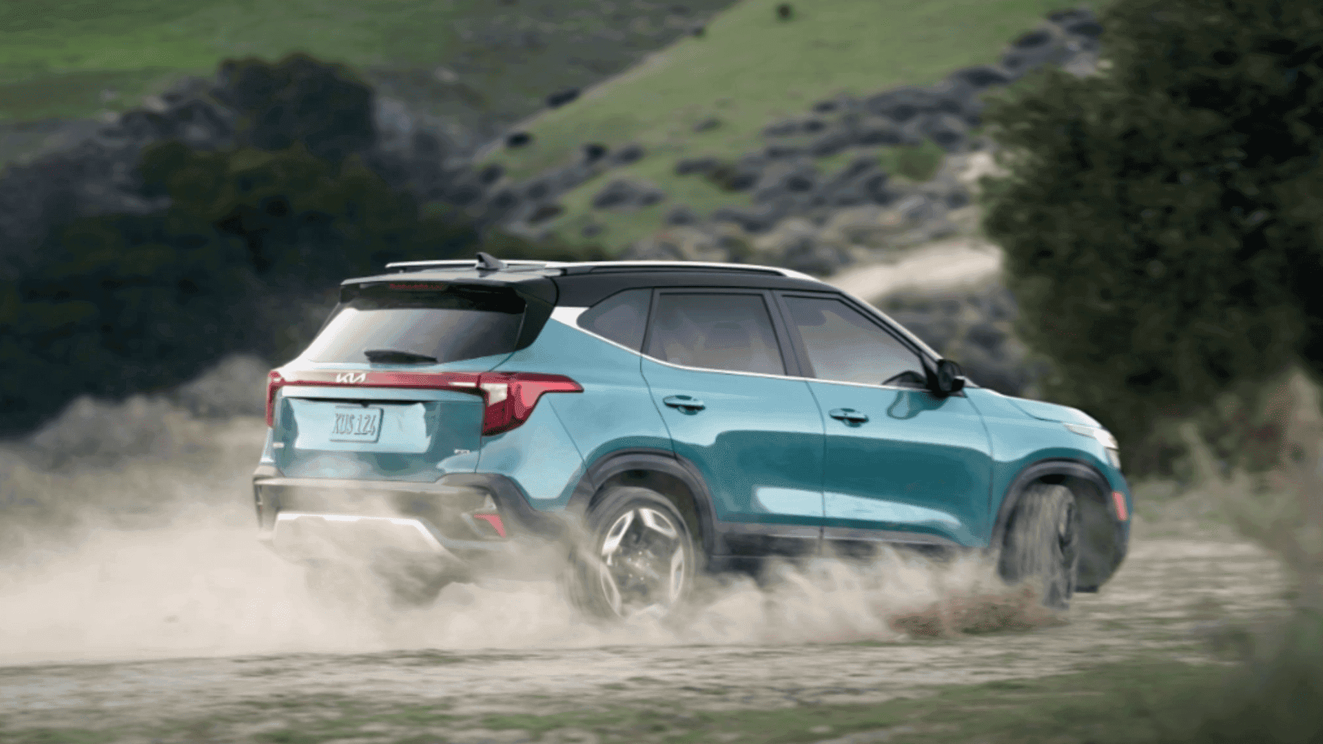 Rear view of the 2024 Kia Seltos kicking up dust on a rugged off-road trail