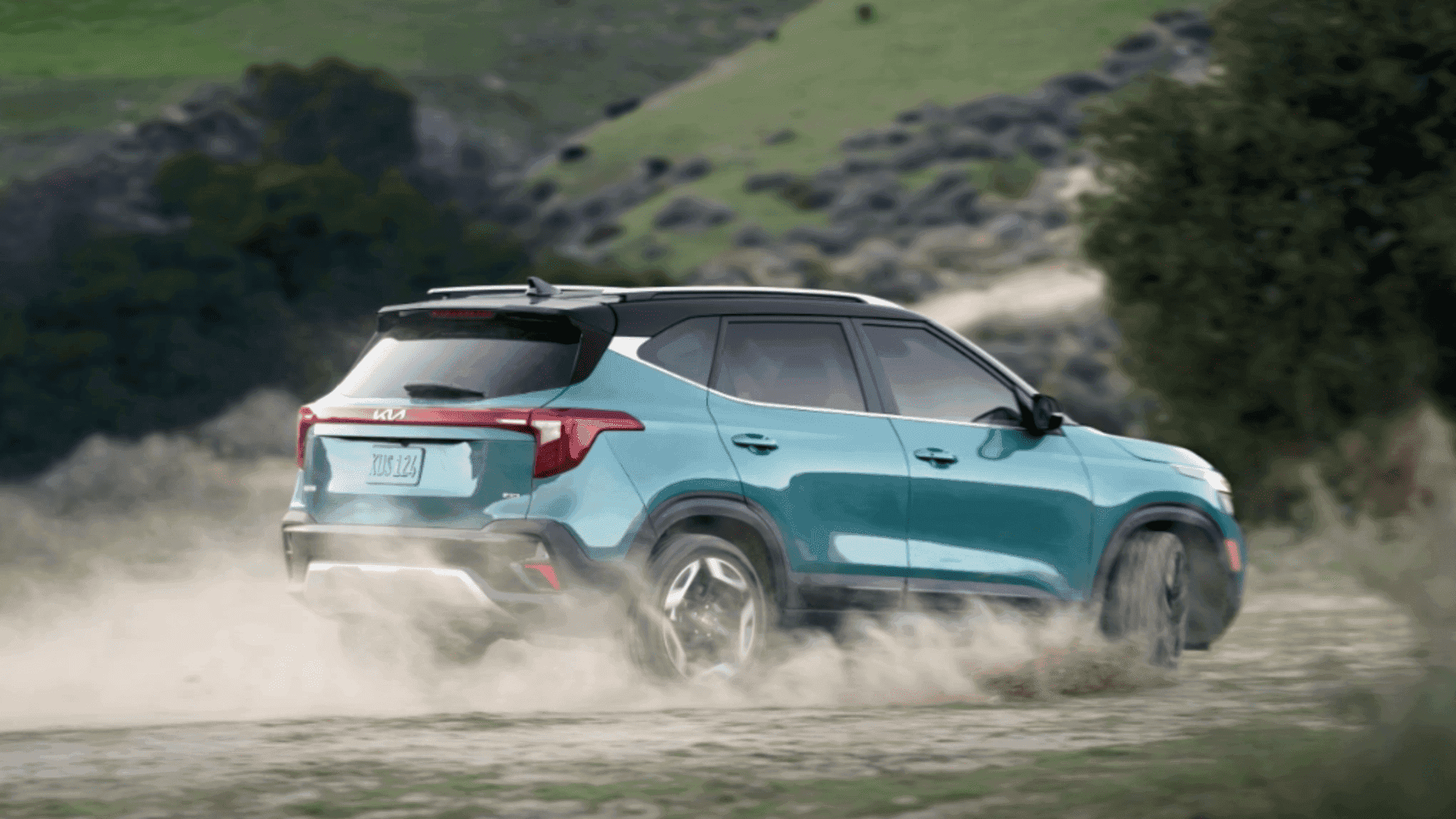 Rear view of a 2024 Kia Seltos kicking up dust on an off-road trail