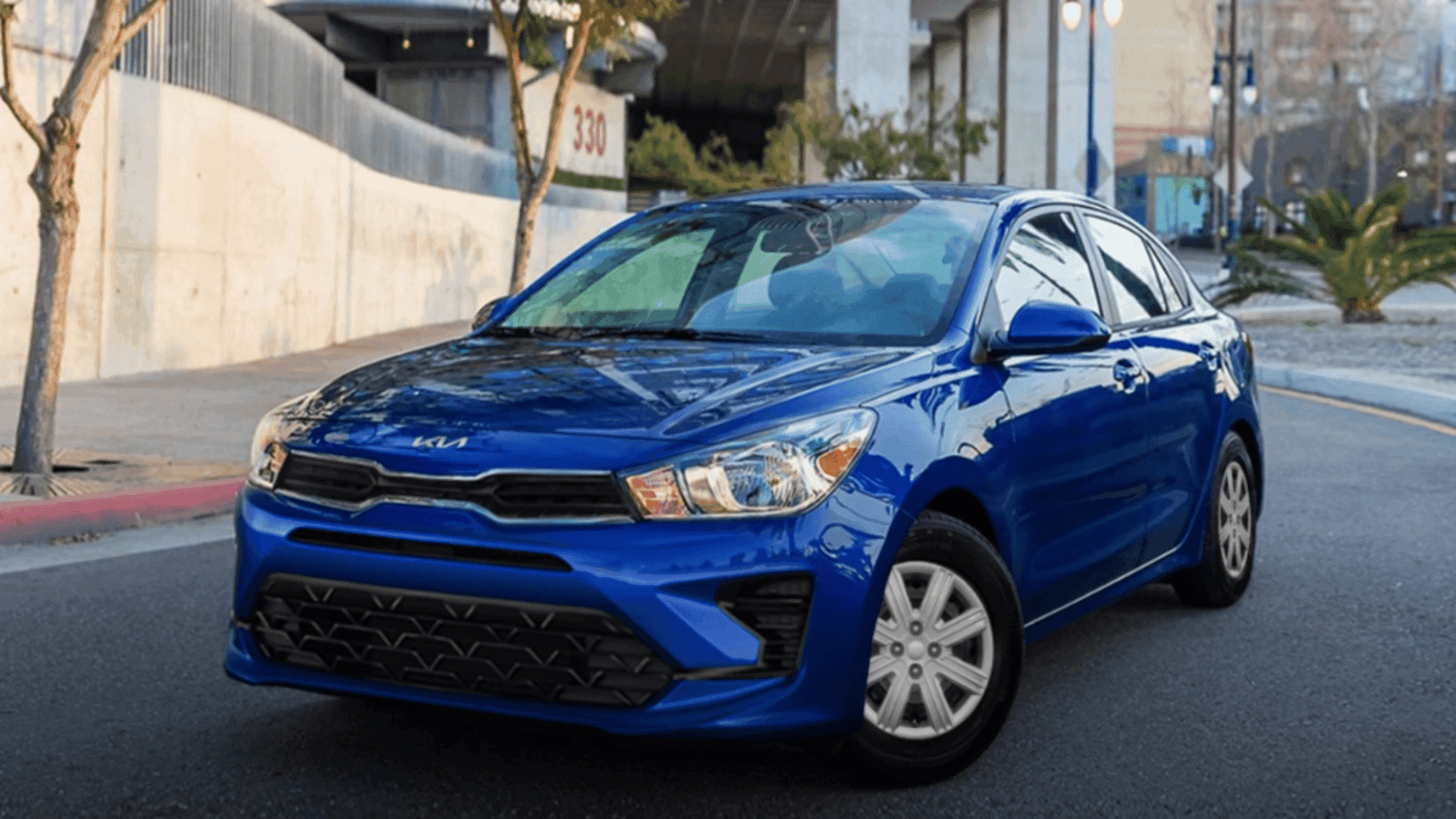 Front angle of blue 2023 Kia Rio parked on an urban street