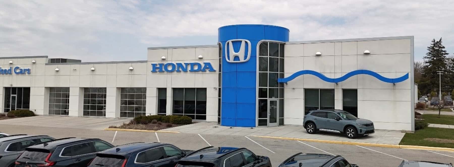 An exterior shot of a Honda dealership during the day.