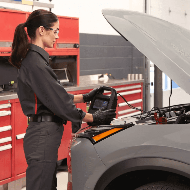 Nissan Technician Performing Battery Inspection Nissan technician checking a vehicle battery and electrical system