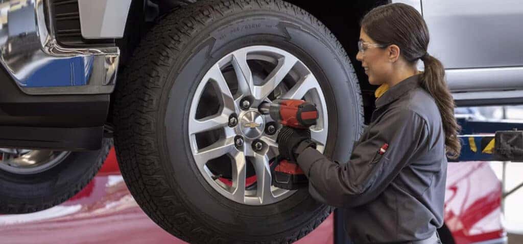 How to check your tires' health at Delaney Chevrolet of Indiana | Chevrolet mechanic removing bolts of a wheel