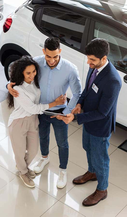 Leasing versus Buying a Hyundai at Delaney Hyundai of Indiana in Indiana, PA | Salesman showing a couple the car options they can get with leasing a vehicle