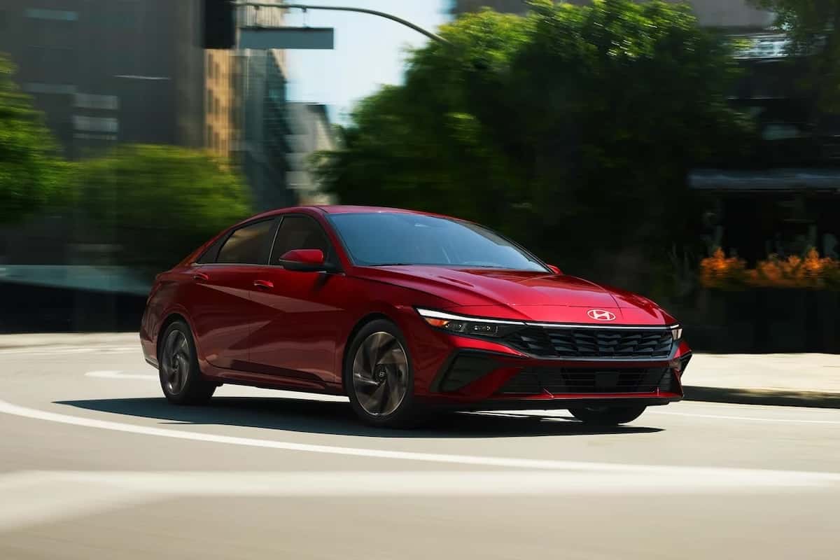 Red Hyundai Elantra driving on a city street