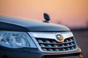 Subaru grill with logo in front of sunset