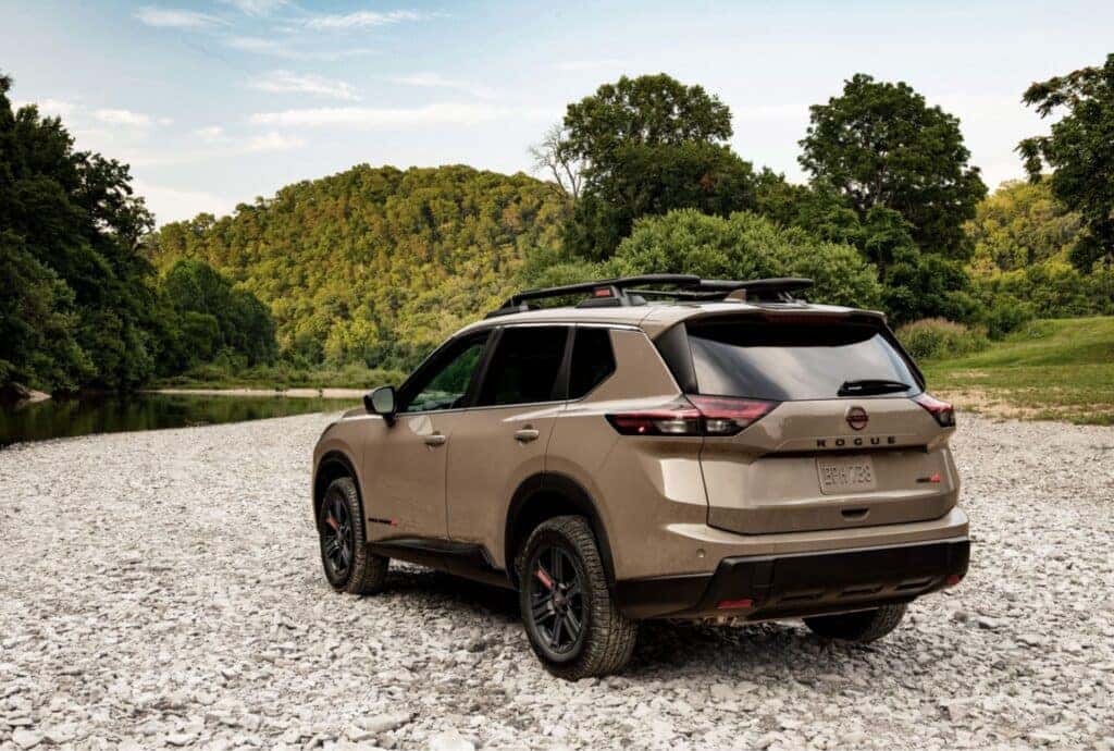 The Strong 2025 Nissan Rogue Driving On Rocky Terrain, Near A Forest
