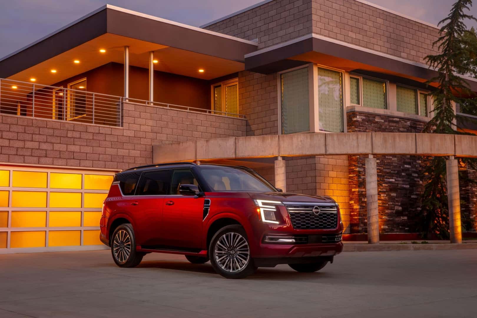 The Fabulous Red Nissan Armada Parked Outside A Brightly Lit Modern Home